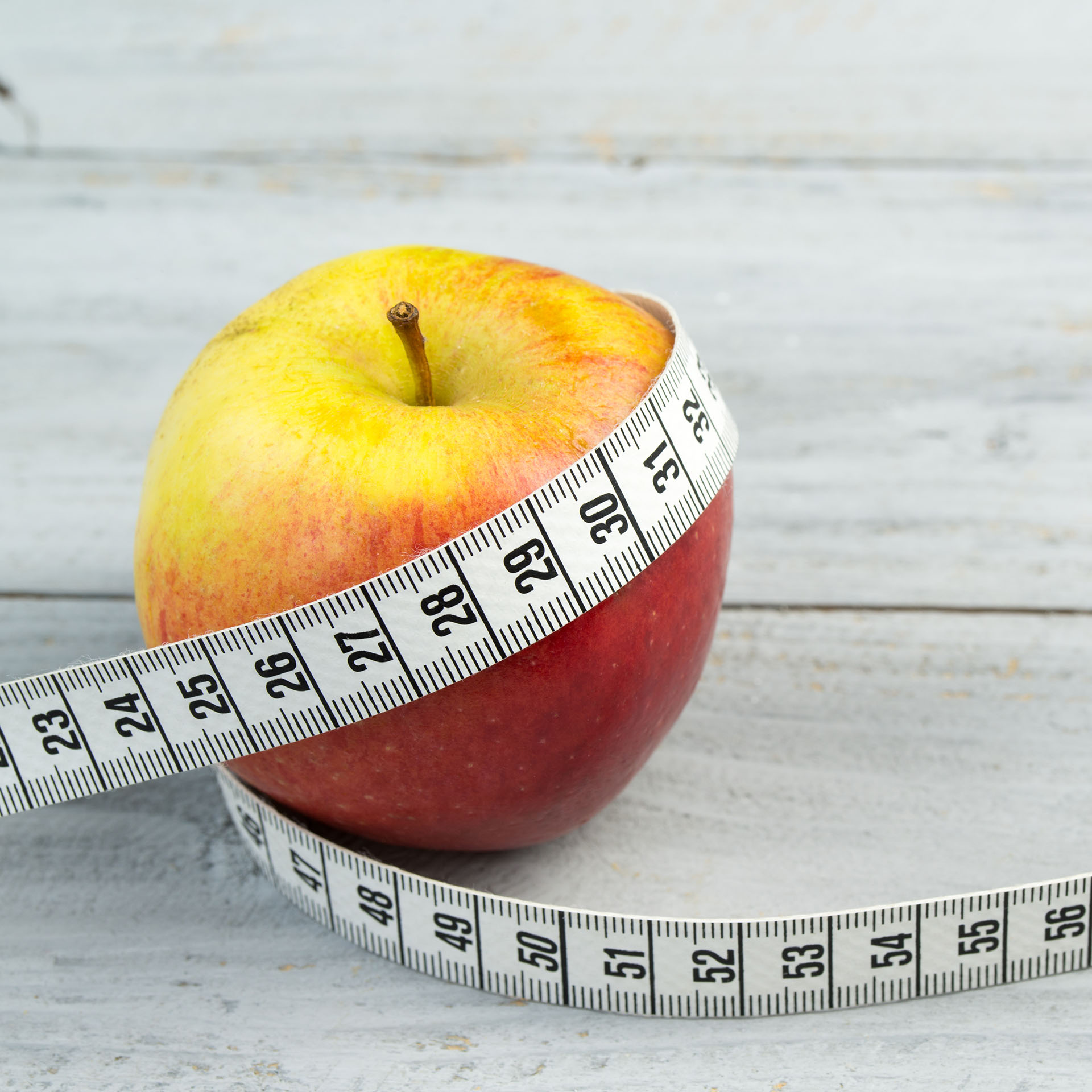 diet fitness, apple with measuring tape wrapped around it