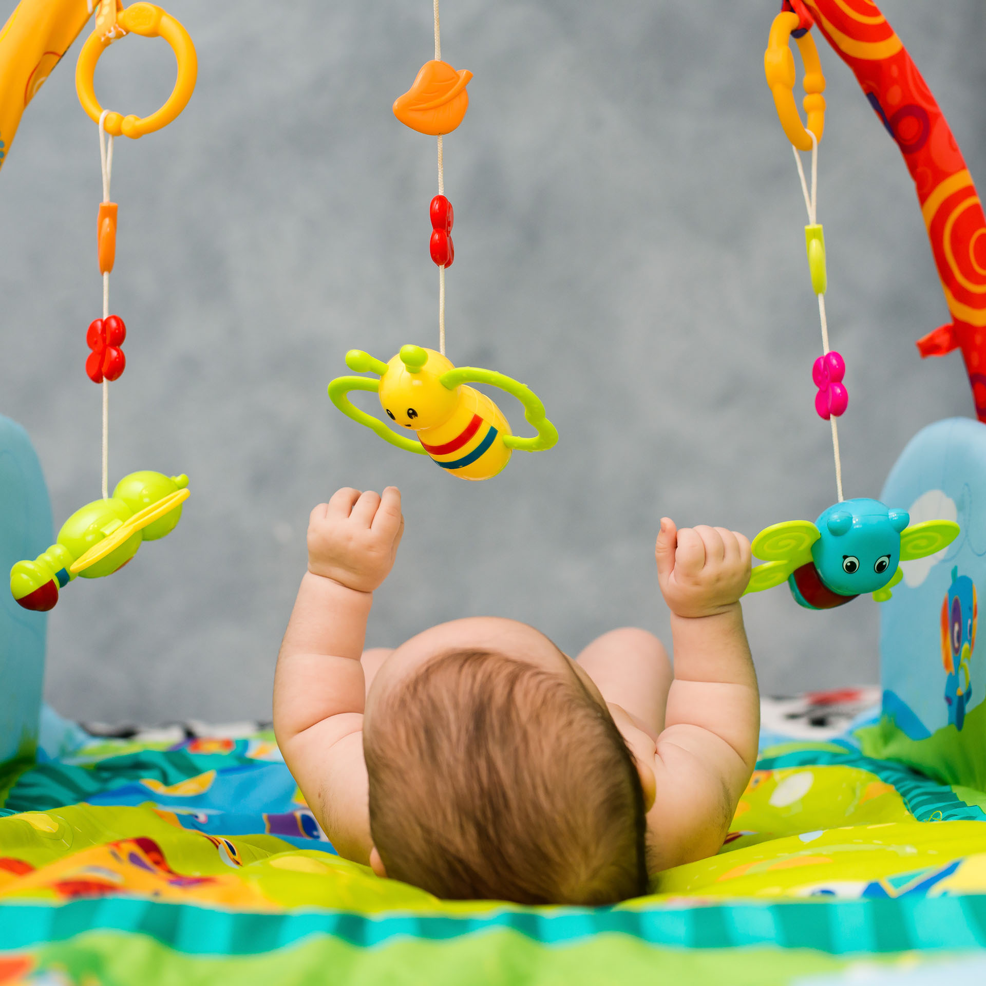 parenting, baby playing with toys in crib